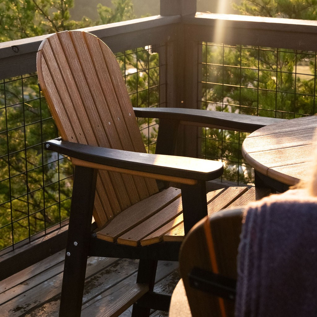Wooden chair and table on a balcony with greenery in the background