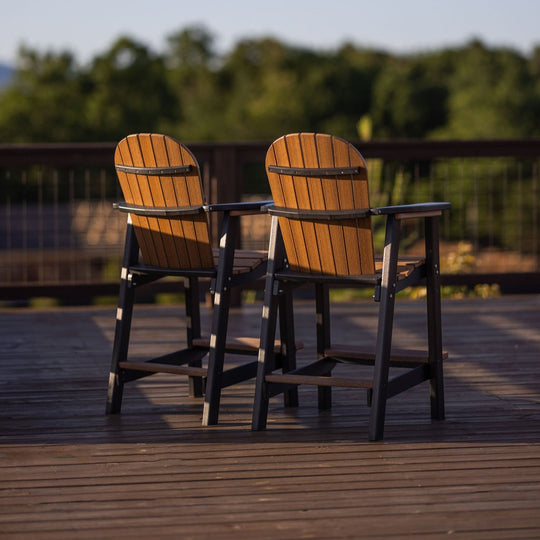 Two wooden chairs on a wooden deck with a blurred natural background