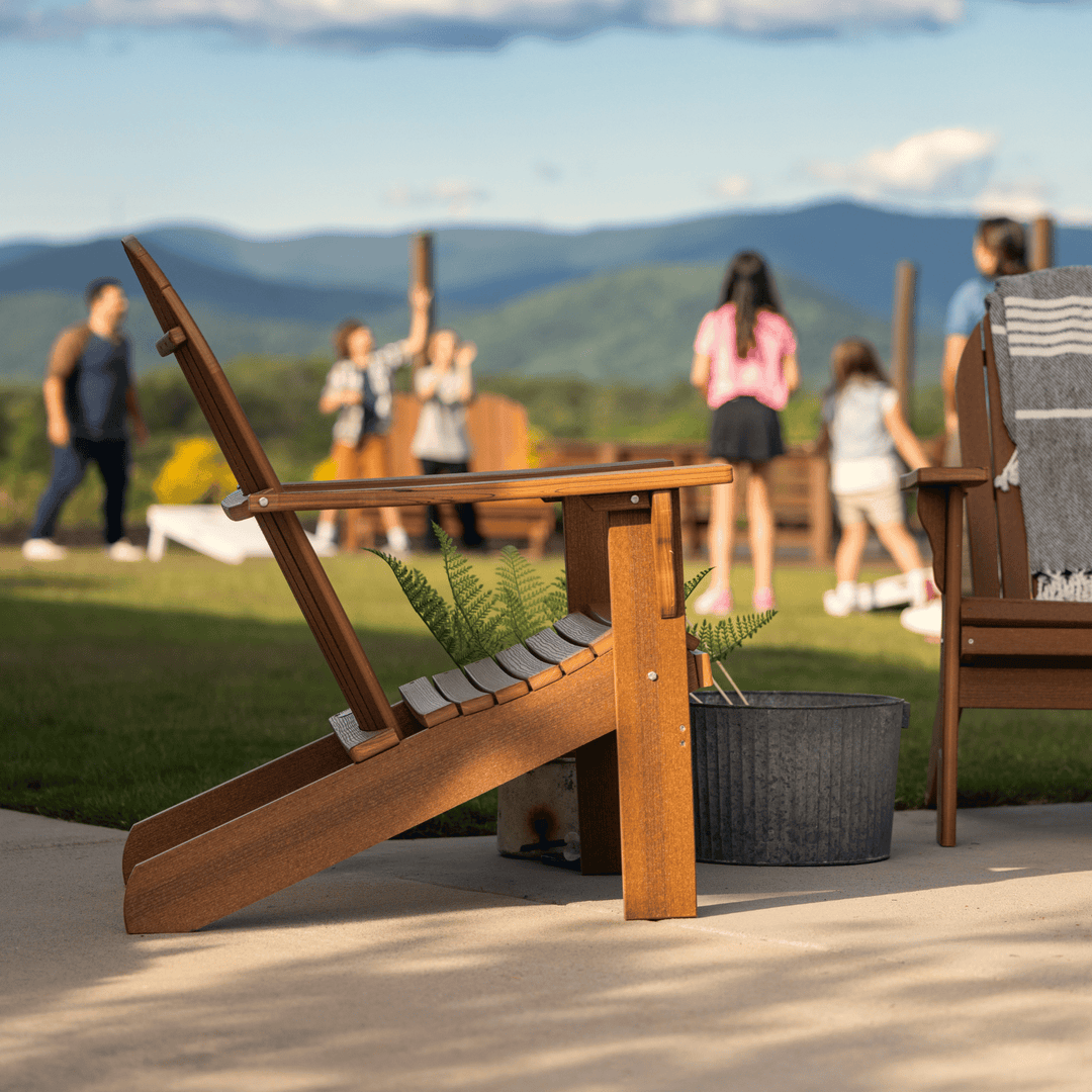 Wooden chair on a patio with people and mountains in the background