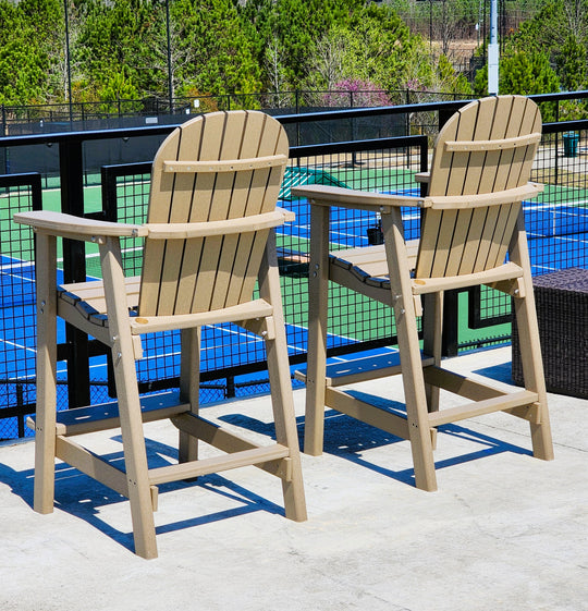 Two wooden chairs on a rooftop with a tennis court in the background
