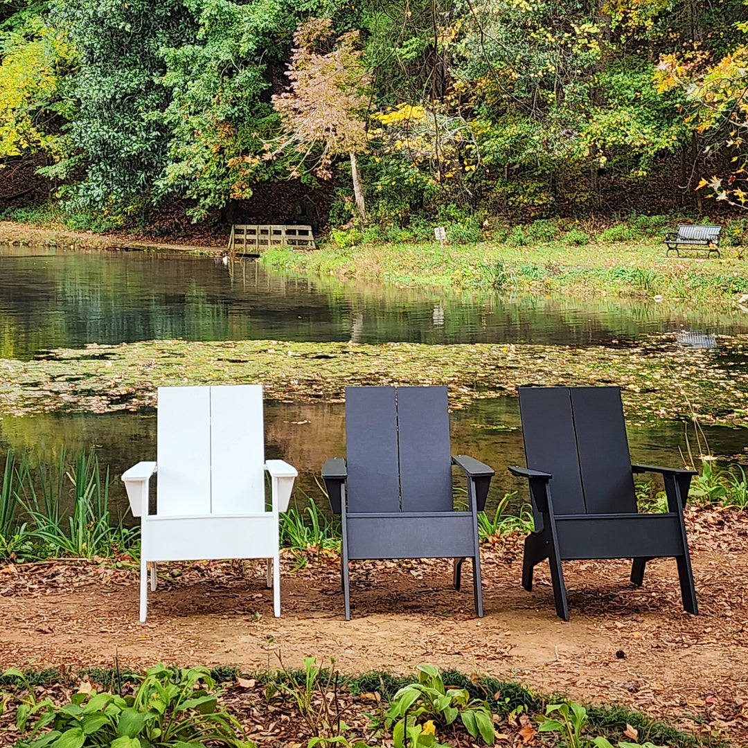 Outdoor furniture set by a pond with trees in the background